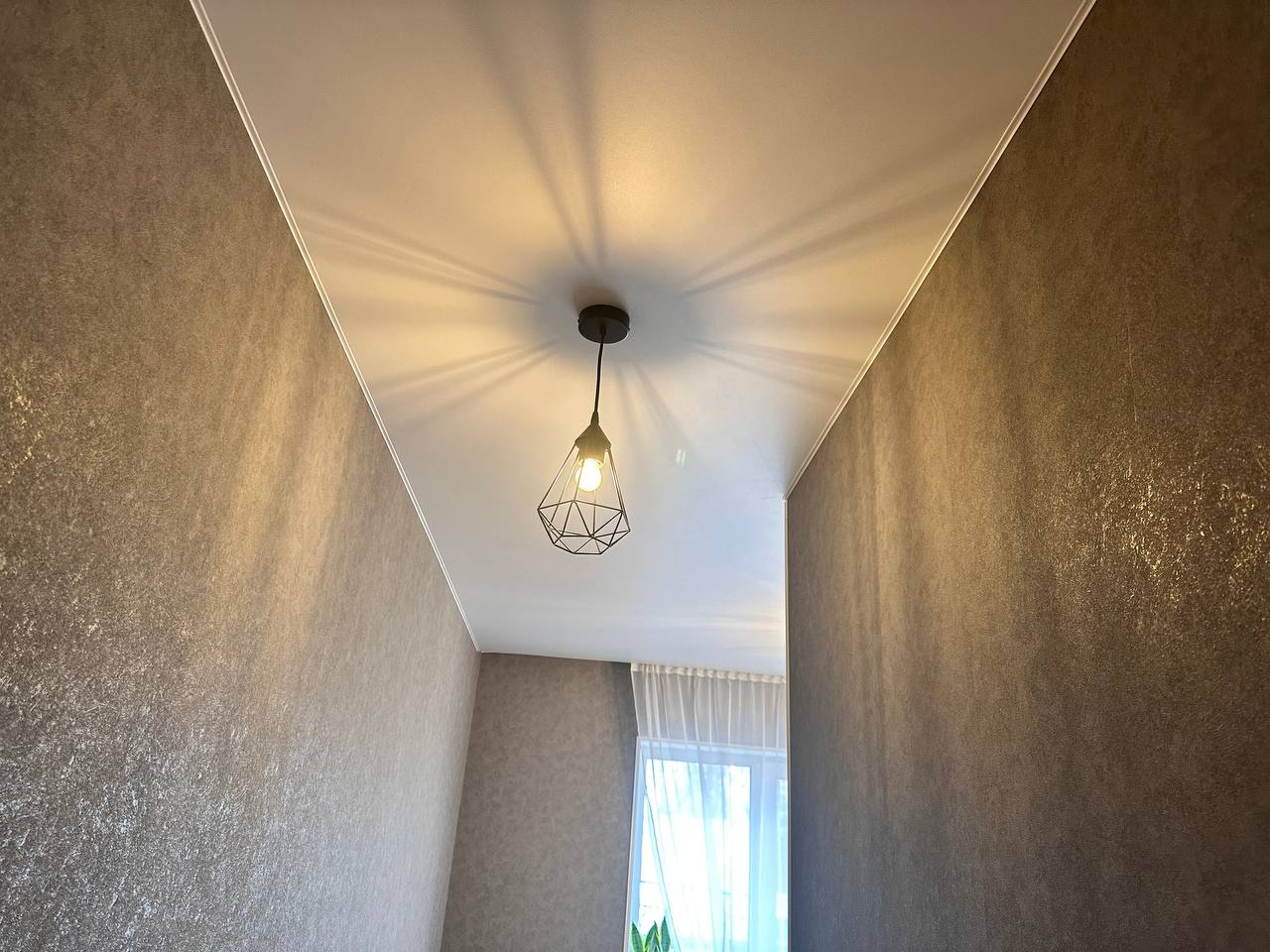 Матовый потолок с люстрой в жилой комнате